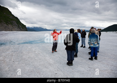 Guía de turismo en la parte superior del glaciar de Mendenhall, cerca de Juneau Alaska enseña y entretiene a los turistas. Foto de stock