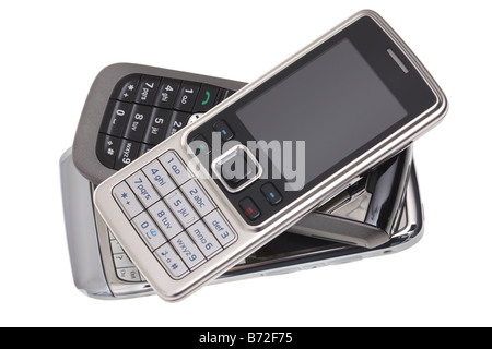 Montón de teléfonos celulares recortadas sobre fondo blanco. Foto de stock
