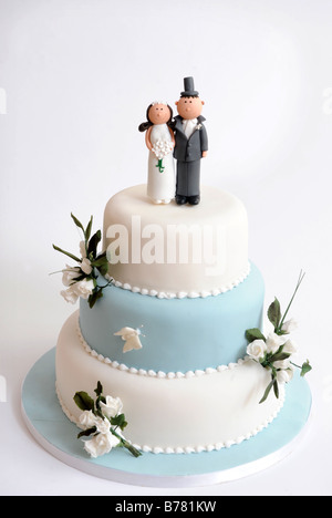 Un pastel de bodas de tres pisos con decoración de flores y figuras para el  novio y la Novia de cómic Fotografía de stock - Alamy