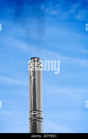 Fumar chimenea de acero contra el cielo azul. Foto de stock