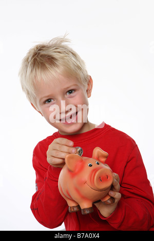 Niño sosteniendo una alcancía Foto de stock