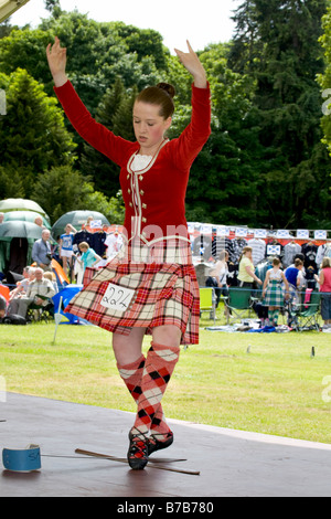 Scottish Highland Games - bailarinas de falda y vestidos de cuadros escoceses de realizar una evaluación individual del molinete de Strathmore reuniendo, Sco Foto de stock