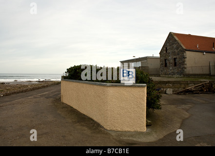Bed and Breakfast pequeño letrero en una pared por un camino con vistas a Moray Firth en Escocia Foto de stock