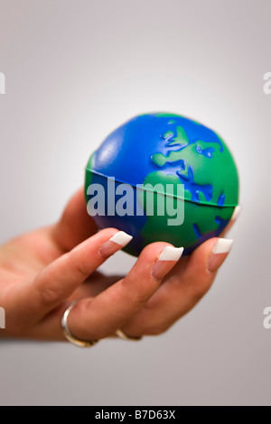 La mano que sostiene la mujer globo de juguete Foto de stock