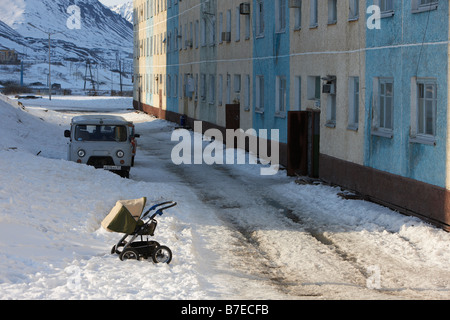 Cochecito de bebé en la nieve por edificio Egvekinot, Chukotka Rusia Siberia Foto de stock