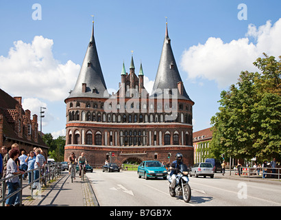 Tráfico y ciclo ruta en Holstentor city gate Lubeck Alemania Foto de stock