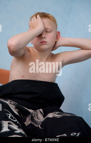 Muchacho adolescente estiramiento en la cama Foto de stock