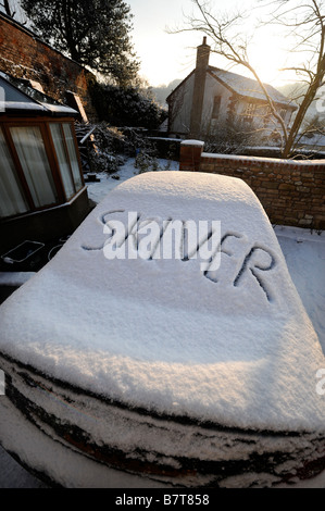 Coche aparcado en un camino con las palabras escritas en la peladora nieve sugiriendo el absentismo laboral durante condiciones invernal moderado U Foto de stock