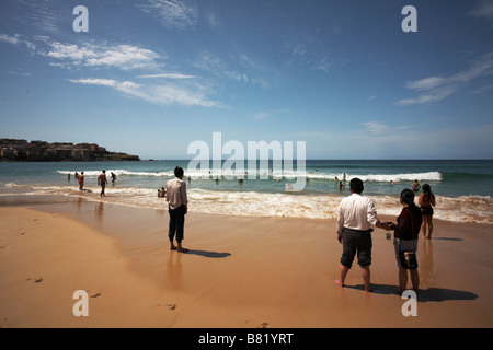 Turista mirando el amanecer en la playa de Bondi, Sydney turistas en primer plano sosteniendo cada otras manos Foto de stock