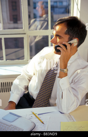 Hombre de negocios en la oficina en el teléfono móvil anticuado, EE.UU. Foto de stock