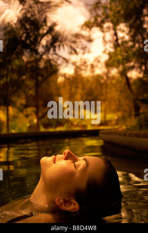 Mujer relajante piscina caliente Blancaneaux Lodge, San Ignacio, Belice Foto de stock