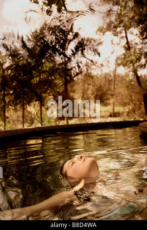 Mujer relajante piscina caliente Blancaneaux Lodge, San Ignacio, Belice Foto de stock