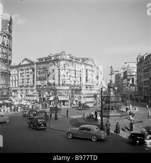 1950s, los coches de la época que iban alrededor de Piccadilly Circus, Londres, Inglaterra, Reino Unido, cuando era una rotonda de trabajo, mirando hacia Shaftesbury Avenue. Foto de stock