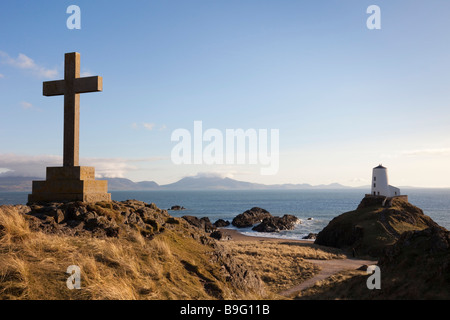 Anglesey al norte de Gales, Reino Unido cruz de piedra Memorial y el antiguo faro Twr Mawr en Rocky Point, en la isla de Ynys Llanddwyn AONB