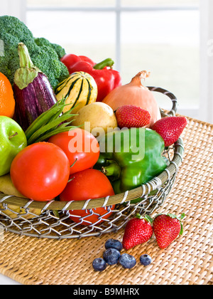 Pila de frutas frescas y hortalizas muestran en una cesta Foto de stock