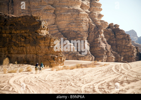 Dos turistas montar camellos en el desierto, Wadi Rum Jordania, Oriente Medio Foto de stock