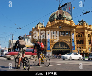 Los ciclistas esperar para cruzar la calle en frente de la estación de tren de Flinders Street Melbourne, Victoria, Australia Foto de stock