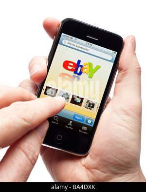 Manos macho utilizando el iPhone y con la aplicación de ebay en un smartphone smart phone teléfono móvil Foto de stock