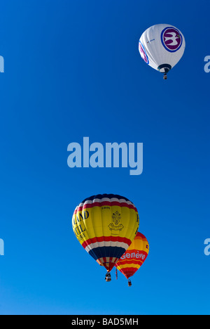 Los globos de aire caliente subiendo hacia el cielo azul claro en el 2009 Chateau d'Oex International Balloon Festival / carreras.