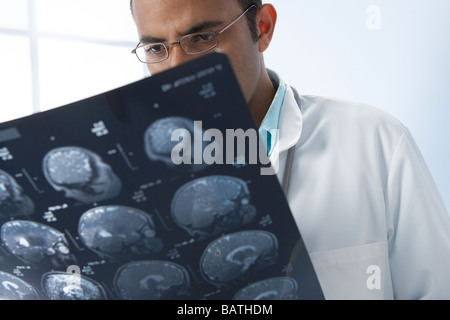 Médico examina las IRM.Los escaneos son sagital (vista lateral) sectionsthrough cabeza de un paciente. Foto de stock