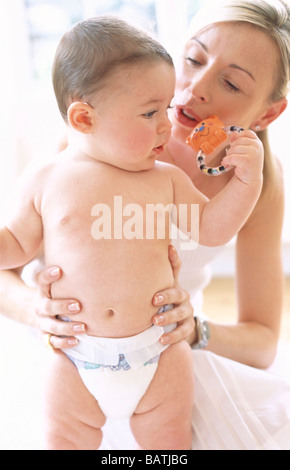 Baby Boy y madre. Hablando con su madre 6-month-old baby boy que está sosteniendo un juguete.