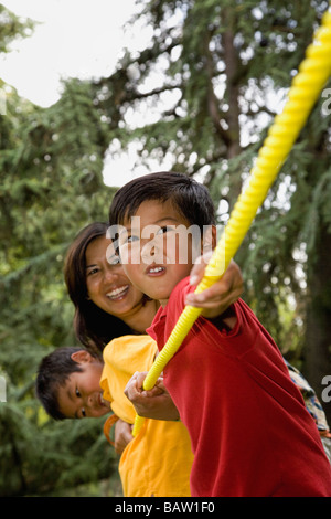 Madre de Asia y sus hijos jugando tug-of-war