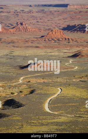 Un camino de tierra serpentea a través del paisaje del desierto hacia el Valle de los dioses. Foto de stock