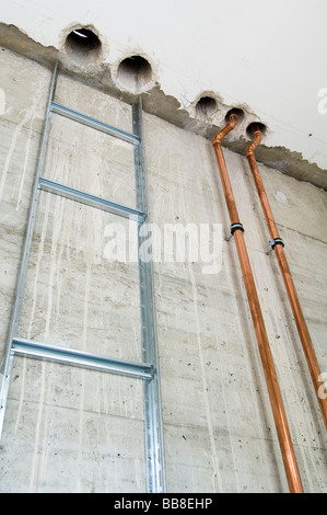 Taladrar los agujeros de perforación en hormigón para líneas de alimentación en un edificio de nueva construcción Foto de stock