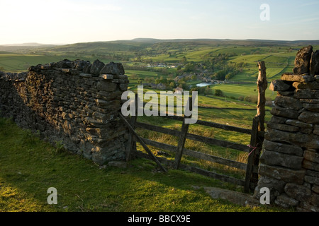 Una pared drystone enmarca la vista hacia la aldea de Burnsall, en Wharfedale, Yorkshire Dales, desde Burnsall cayó Foto de stock
