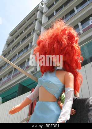 Niña muñeca con cabello rojo brillante en la calle de la ciudad Foto de stock