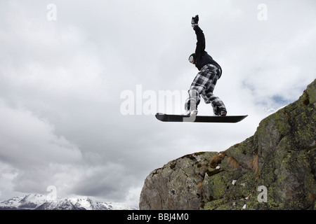 Snowboarder salta un precipicio en la estación de esquí de Les Deux Alpes, parte de la Grande Galaxie, la zona de esquí de los Alpes, Francia Foto de stock