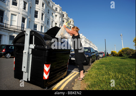 Una mujer utiliza uno de los contenedores comunales recién instalada en la zona de la ciudad de Kemp de Brighton Foto de stock