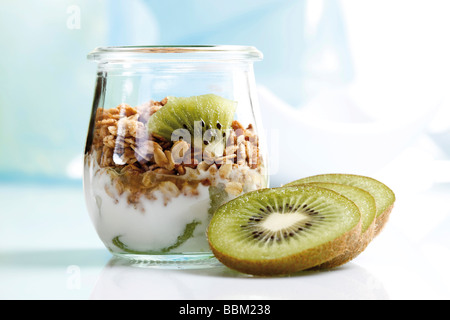 Muesli con yogur y kiwi en pequeños frascos de vidrio Foto de stock