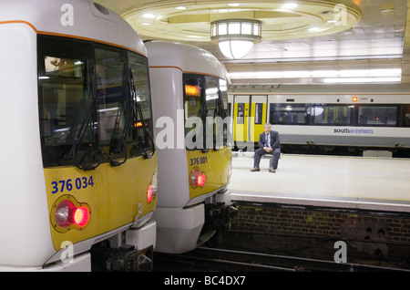 Un Commuter está esperando un tren, la estación de tren de Charing Cross, Londres, Reino Unido Foto de stock