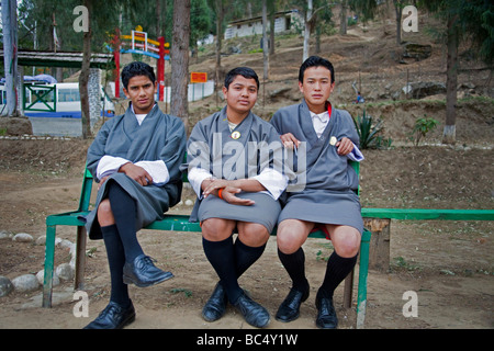 Los jóvenes monjes novicios en gris unifiorms estudiantes sentados en banco fuera Punakha Dzong monasterio 91588 Bhutan-Punakha .Horizontal Foto de stock