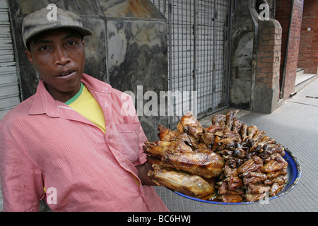 Madagascan hombre llevando una bandeja de pollo frito en Antananarivo, Madagascar