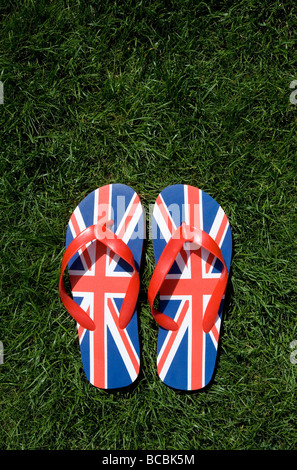 Union Jack flip-flops sobre hierba Foto de stock