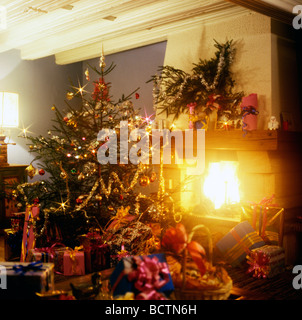 Regalos bajo el árbol de Navidad y la chimenea. Foto de stock