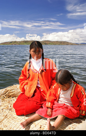 Dos niñas de una de las islas flotantes de los Uros en el lago Titicaca, Perú. Foto de stock