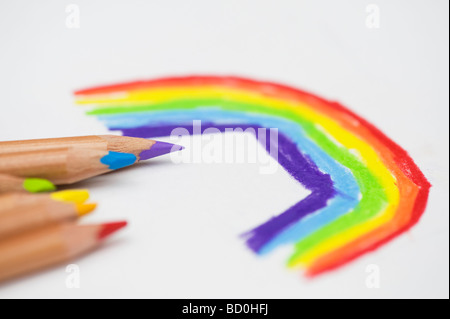 Childs del arco iris de dibujo con lápices de colores sobre papel blanco