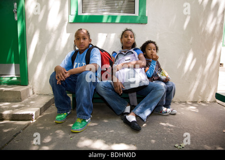 Selena Pina, una madre sin hogar de cuatro hijos, con sus hijos en la escuela de Semillas de Mostaza en Panes y Peces en Sacramento, CA. Foto de stock