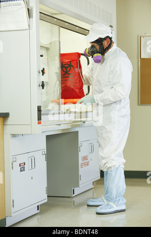 Scientist colocando una bolsa para residuos con riesgo biológico en una campana de humos Foto de stock