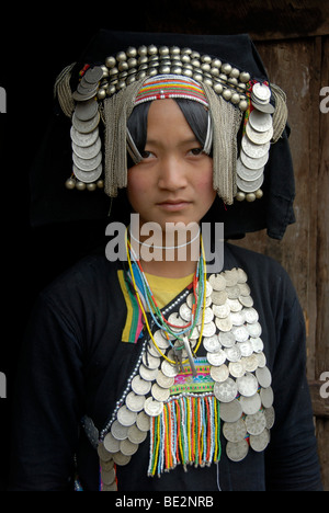 Retrato, etnología, mujer Akha Pixor grupo étnico en traje tradicional, capó como un tocado, muchas monedas de plata como joya Foto de stock