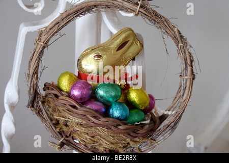 Canasta de Pascua con chocolate conejo y huevos de chocolate Foto de stock