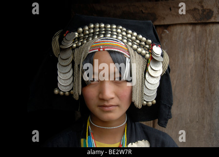 Retrato, etnología, mujer Akha Pixor grupo étnico en traje tradicional, capó como un tocado, muchas monedas de plata como joya Foto de stock