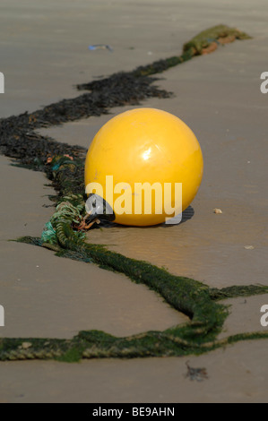 La boya amarilla sobre una playa de arena Foto de stock