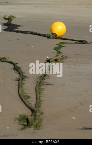 La boya amarilla sobre una playa de arena Foto de stock