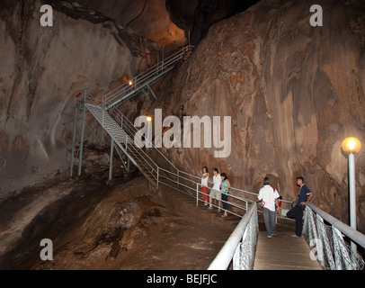 Gua Tempurung cueva interior mostrando gran stalacmite y turistas en pasarelas. Foto de stock