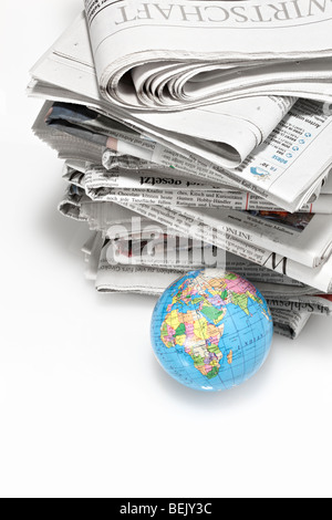 Ein Stapel Zeitungen mit Weltkugel Foto de stock