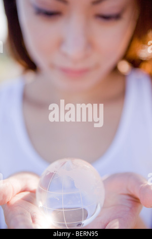 Mujer joven sosteniendo globo en las manos, cerrar